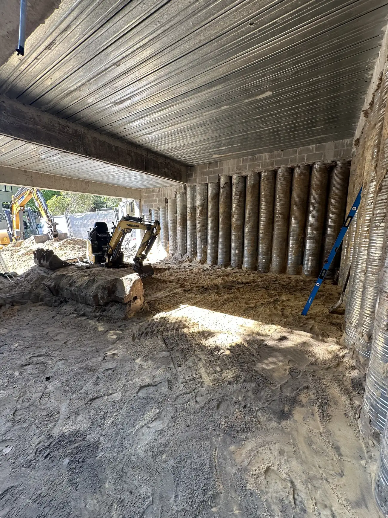 Bulk excavation beneath a suspended slab against a shored pile wall